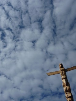 BC totem pole against blue sky with clouds, Stanley Park
