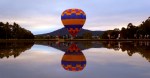 hot air balloon preparing to take off reflection water